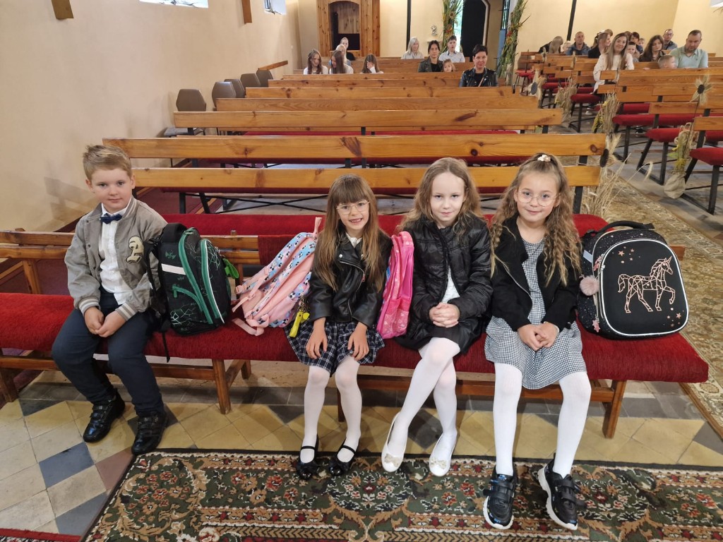 Uczniowie klasy pierwszej przed poświęceniem plecaków